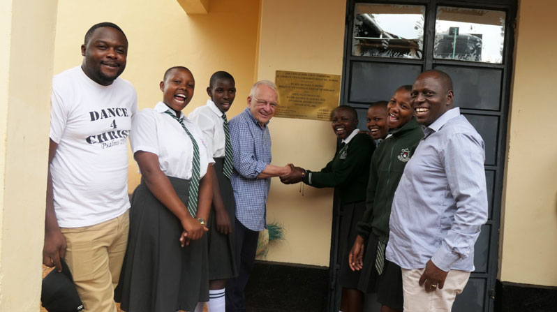 Students from Kebaroti Secondary School join Maryknoll Fathers Joshua Maondo (left) and Lance Nadeau, superior general of Maryknoll Fathers and Brothers (center), and Migori County Deputy Governor Joseph Mahiri (right) to celebrate a new dormitory that offers girls a safe place to live and study. (Courtesy of Lance Nadeau/Kenya)