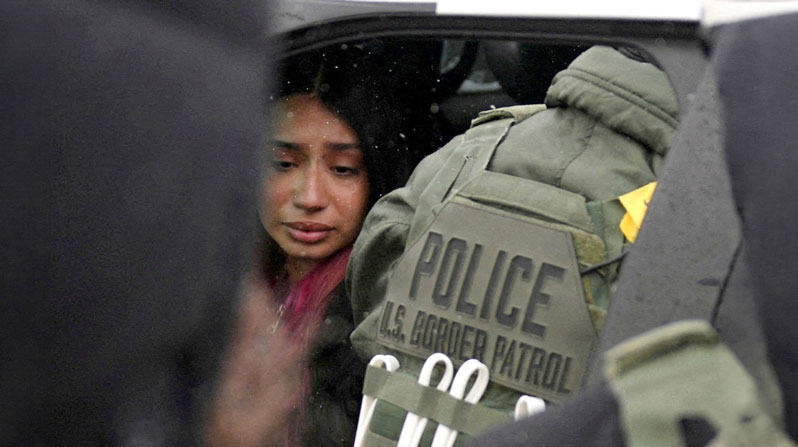A detained woman sits inside a vehicle surrounded by federal agents in Minneapolis Jan. 21, 2026. (OSV News/Leah Millis, Reuters)