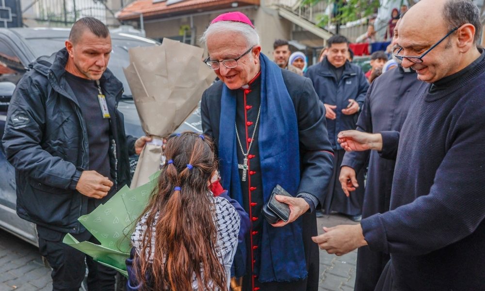 Auxiliary Bishop William Shomali of the Latin Patriarchate of Jerusalem, center, and Father Gabriel Romanelli, pastor of Gaza City’s Holy Family Parish in Gaza City, right, greet children as Cardinal Pierbattista Pizzaballa, Latin patriarch of Jerusalem, visits the church compound during his Christmas pastoral visit Dec. 15, 2025. The school at Holy Family Parish reopens in fall 2026 for the first time since the start of Israel’s military campaign. (OSV News/courtesy Latin Patriarchate of Jerusalem)