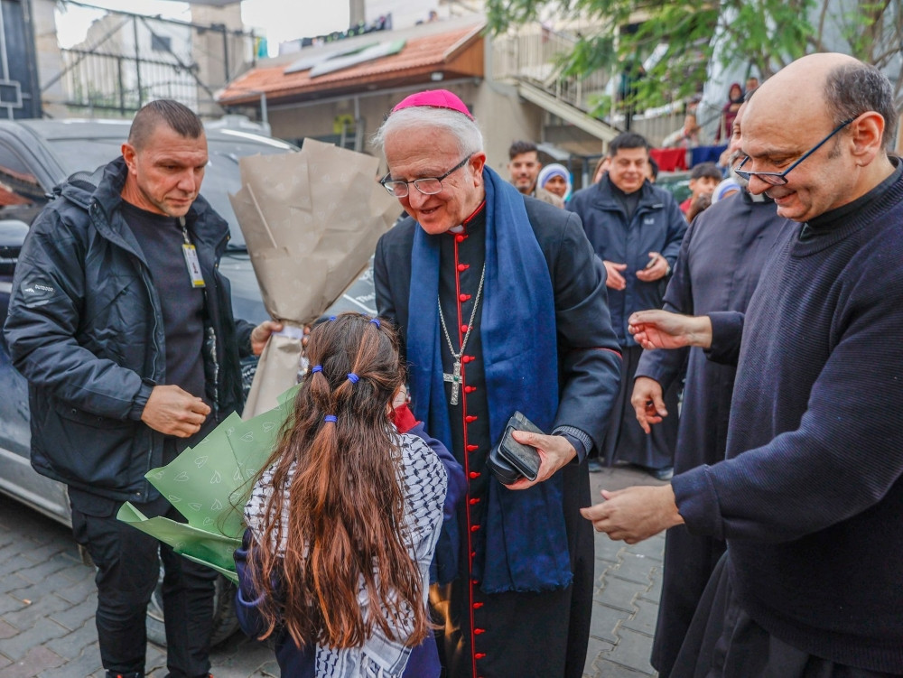 Auxiliary Bishop William Shomali of the Latin Patriarchate of Jerusalem, center, and Father Gabriel Romanelli, pastor of Gaza City’s Holy Family Parish in Gaza City, right, greet children as Cardinal Pierbattista Pizzaballa, Latin patriarch of Jerusalem, visits the church compound during his Christmas pastoral visit Dec. 15, 2025. The school at Holy Family Parish reopens in fall 2026 for the first time since the start of Israel’s military campaign. (OSV News/courtesy Latin Patriarchate of Jerusalem)