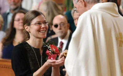 Maryknoll Sister Julia Shideler smiles as she receives communion from the late Maryknoll Father John (Jack) Sullivan during her Profession of Perpetual Vows Mass on September 28, 2014, at the Maryknoll Sisters Center in Ossining, New York. (Gregory A. Shemitz/CNS/U.S.)