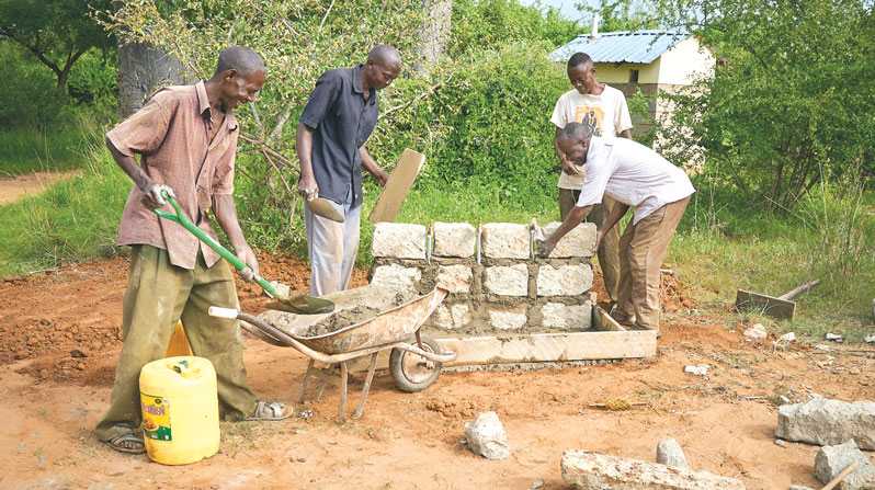 Workers put finishing touches on a water point at St. Michael the Archangel Church in Kamboo. The wider Kibwezi region has been devastated by climate change. (Paul Jeffrey/Kenya)