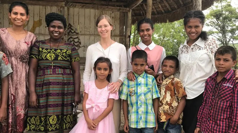 Sister Shideler, shown with Maryknoll Sister Susan Wanzagi (second from left) and with children from Daisoli village after a Mass in 2018, served for 14 years in Timor-Leste, working in education and pastoral ministry. (Courtesy of Julia Shideler/East Timor)