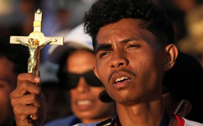 A man holds a crucifix as Pope Francis celebrates Mass at Taci Tolu Park in Dili, East Timor, during the pope’s 2024 apostolic trip. (OSV News/Dita Alangkara/Reuters/East Timor)