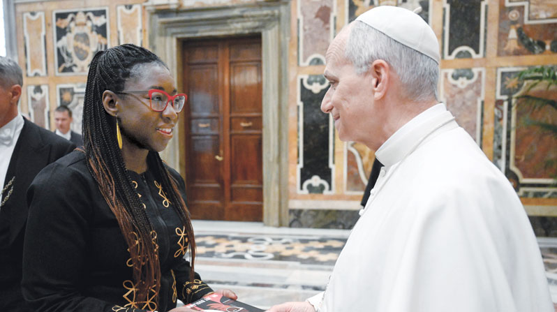 Joy Buolamwini, a computer scientist, presents a copy of her book to the pope at a Vatican conference on artificial intelligence Nov. 13, 2025. (CNS/Vatican Media/Vatican City)