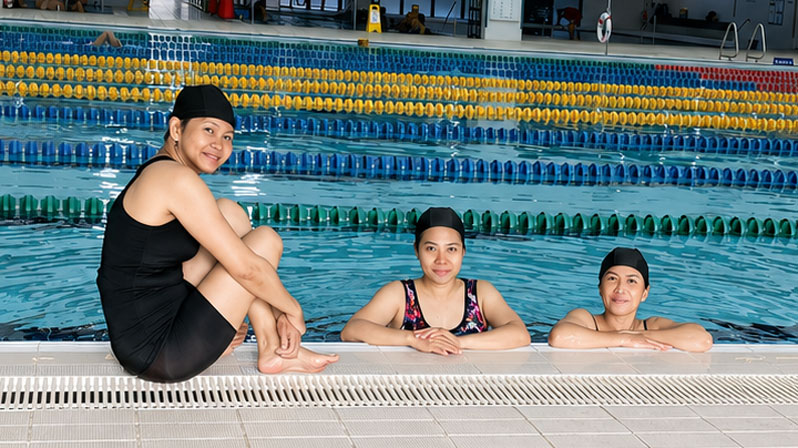Three women from the shelter for migrant workers run by Maryknoll Father Joyalito Tajonera as part of the parish ministry of Tanzi Catholic Church in Taiching, Taiwan, take a swim at a local pool, encouraged by Maryknoll volunteer Antonia Soave. (Courtesy of Antonia Soave/Taiwan)