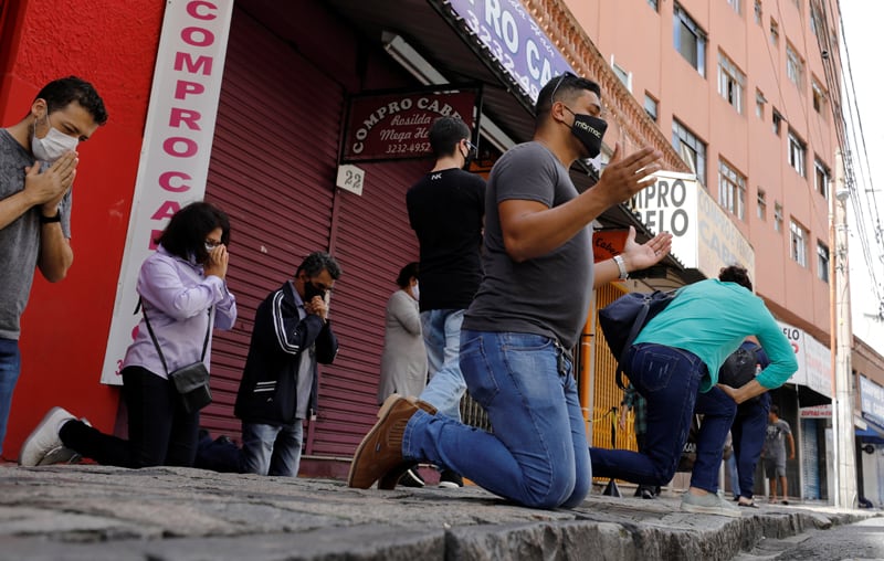 Las personas se arrodillan en oración durante una misa de Pascua fuera del Santuario de Nuestra Señora de Guadalupe en Curitiba, Brasil, el 4 de abril de 2021, durante la pandemia de COVID-19. (Foto del CNS / Rodolfo Buhrer, Reuters)