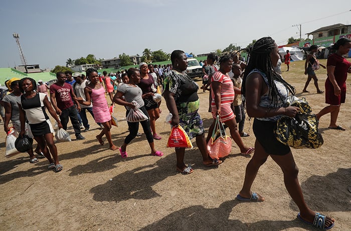 Residentes que fueron evacuados de sus hogares luego de un terremoto caminan luego de recibir comida en un estadio en Les Cayes, Haití, en esta foto de archivo del 23 de agosto de 2021. Informe publicado por varias agencias de Naciones Unidas advirtió un aumento en el número de personas que padecen hambre en América Latina y el Caribe. (Foto del CNS / Henry Romero, Reuters)