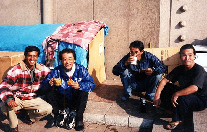 En Japón, Merwyn De Mello visita a unos amigos indigentes que vivían en cajas de cartón en un camino pavimentado a lo largo del río Sumida de Tokio. Cada semana, De Mello les llevaba bolas de arroz hechas por un grupo al que pertenecía, compuesto principalmente por ancianas japonesas y un sacerdote franciscano. (Cortesía de Merwyn De Mello/Japón)