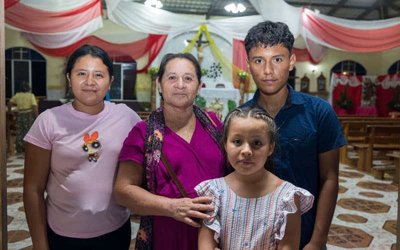 Juan Yancarlos Imanol Rojas Martínez, uno de los 20 becados por el Padre Senger, asiste a Misa en El Remate con parientes. (Octavio Durán, OFM/Guatemala)