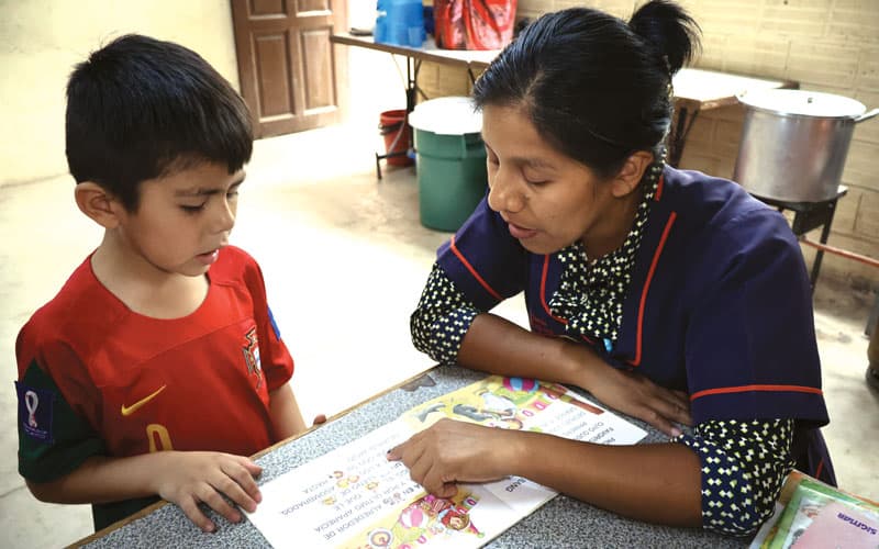 La tutora Beatriz Beltrán le enseña a leer a Ezequiel, un estudiante de primer grado que recibe tutoría en el proyecto Apoyo Escolar.
(Adam Mitchell/Bolivia)