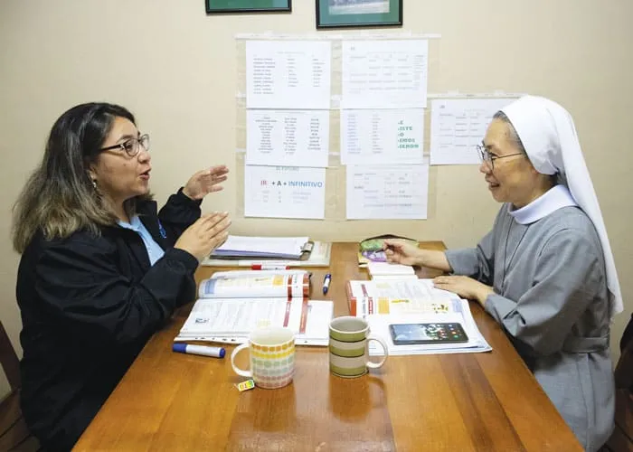 Karla Rojas (izquierda), de la nueva escuela de idiomas, instruye a la alumna Hermana Kang JuJin de Corea en una de las instalaciones del centro Maryknoll en Cochabamba, Bolivia. (Adam Mitchell/Bolivia)