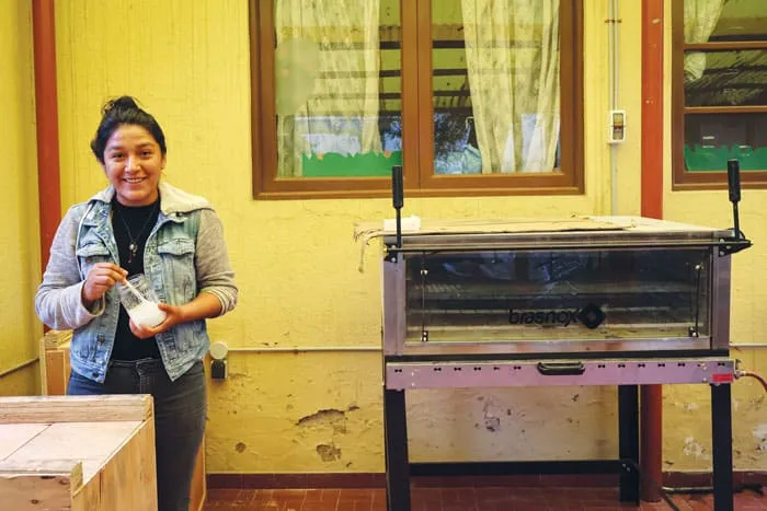La sonriente joven boliviana Mercedes Sayqua de la organización Kawsay desarrolla un producto natural para el cabello utilizando hierbas tradicionales de la zona. (Adam Mitchell/Bolivia)