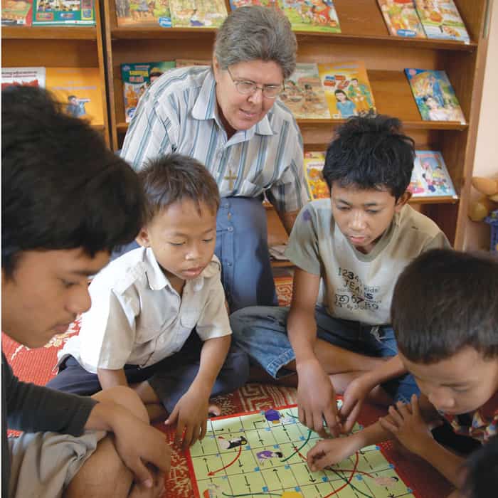 La Hermana Maryknoll Regina Pellicore motiva la participación de sus estudiantes con un juego de mesa didáctico en la aldea de Boeng Tumpun en Camboya. (Sean Sprague/Camboya)