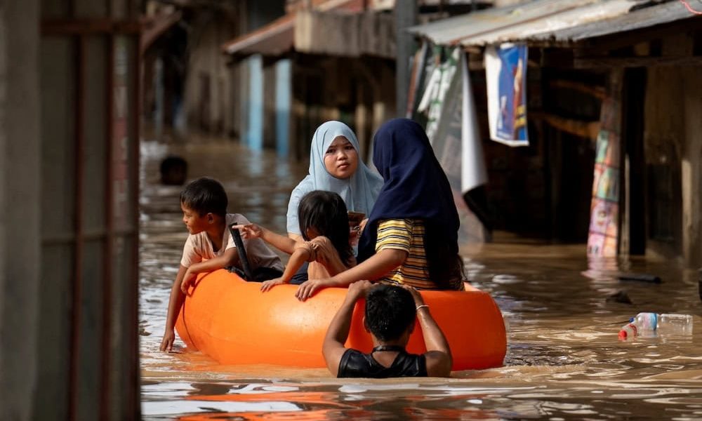 Un grupo de personas flota en un bote de rescate en una calle inundada en Nueva Ecija, Filipinas, el 18 de noviembre del 2024, después del paso del tifón Man-yin que dejó un saldo de por lo menos siete muertos tras un derrumbe, viviendas destruidas y causó el desplazamiento de un gran número de damnificados antes de su paso por el norte de las Filipinas, lo que recrudeció una crisis provocada por tormentas consecutivas, dijeron oficiales. (OSV News/Lisa Marie David, Reuters)