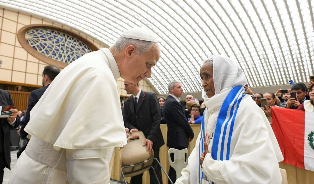 El Papa León XIV saluda a una mujer durante una reunión de movimientos populares o movimientos sociales como parte de su Jubileo en la Sala de Audiencias Pablo VI del Vaticano, el 23 de octubre de 2025. (CNS/Vatican Media)