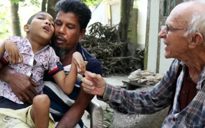 Abdul Mannan Khan y su hijo discapacitado Abu Mosa Khan se reúnen con el Padre Robert T. McCahill en su hogar en el distrito de Munshigonj, Bangladesh, el 18 de noviembre de 2025. El sacerdote visita aldeas a diario para encontrar niños discapacitados y conectarlos con tratamiento médico. (Stephan Uttom Rozario/Bangladesh)