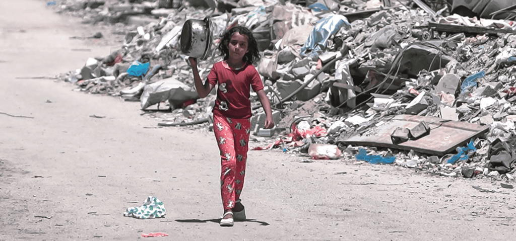 Una niña camina en Gaza durante la guerra entre Gaza e Israel con una olla para conseguir comida el 25 de agosto del 2024. (Jaber Jehad Badwan, vía Wikimedia Commons)