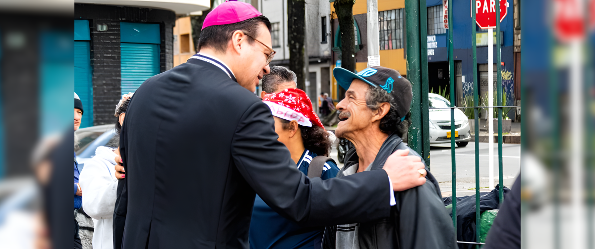 El Obispo Auxiliar de Bogotá, Mons. Alejandro Díaz conversa con una persona necesitada en el barrio de Santa Fe durante la Navidad Jubilar en las Periferias. (Cortesía Diana Bonilla/Colombia)