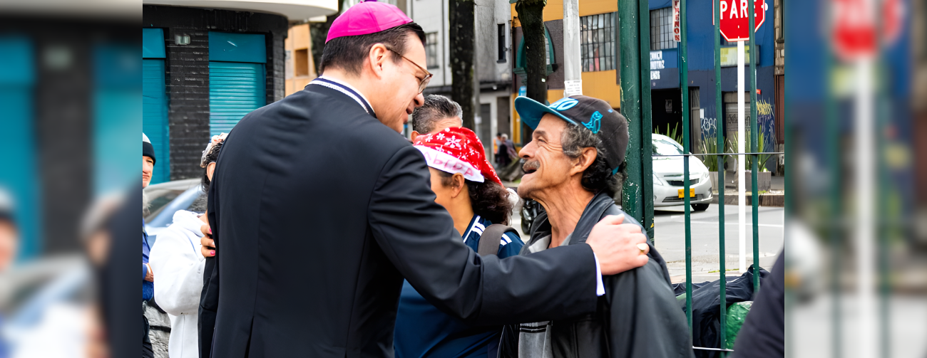 El Obispo Auxiliar de Bogotá, Mons. Alejandro Díaz conversa con una persona necesitada en el barrio de Santa Fe durante la Navidad Jubilar en las Periferias. (Cortesía Diana Bonilla/Colombia)