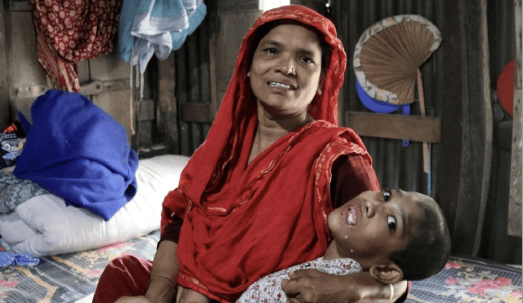 Abu Mosa Khan en brazos de su madre en su hogar en el distrito de Munshigonj, Bangladesh, el 18 de noviembre de 2025. Gracias a la ayuda del P. McCahill, la familia tiene acceso a tratamiento hospitalario gratuito en Daca. (Stephan Uttom Rozario/Bangladesh)