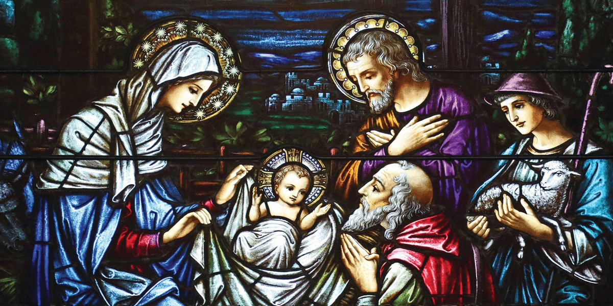 Una hermosa imagen de vidrieras de María, José y otros reunidos en un pesebre rodeando al niño Jesús