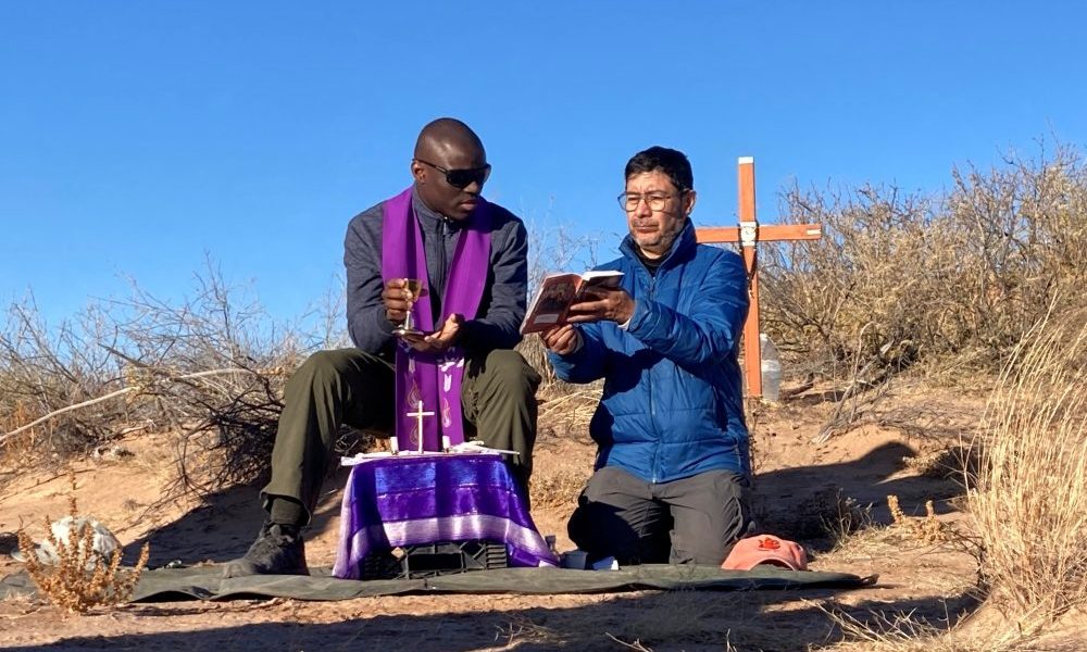 Dos sacerdotes jesuitas no identificados concelebran una misa en el desierto de Chihuahua, en Nuevo México, el 21 de diciembre de 2025, por una mujer guatemalteca de 20 años, cuyos restos fueron recuperados previamente en la zona marcada por la cruz, y también por dos mujeres cuyos restos fueron encontrados el 19 de diciembre. (OSV News/cortesía de Collin Price)