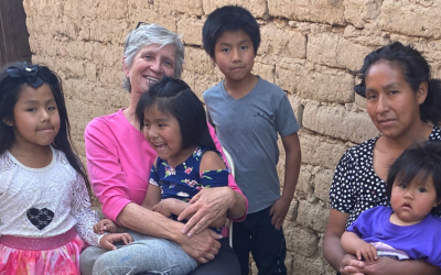 La misionera laica Maryknoll Louise Locke (de camiseta rosa) visita a Lourdes, una madre con cinco niños de los cuales uno sufre de discapacidad, en una comunidad empobrecida en las afueras de Cochabamba, Bolivia. (Cortesía de Louise Locke/Misioneros Laicos Maryknoll/Bolivia)
