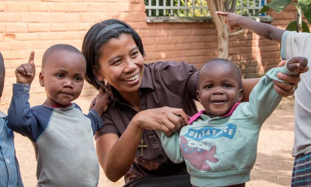 La Hermana Maryknoll Genie Natividad ayuda a los niños con ejercicios de sanación del trauma en la Fundación Karibu (“Bienvenida”) para niños maltratados, fundada por una mujer canadiense con el fin de ayudar a poner fin al maltrato infantil. (Nile Sprague/Tanzania)