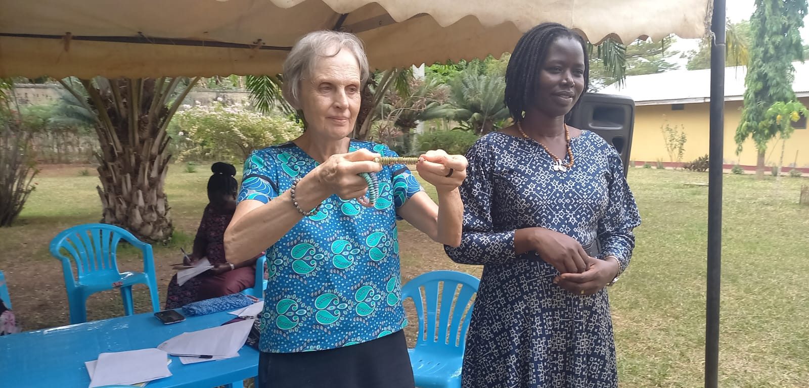 La Misionera Laica Maryknoll Joanne Blaney (izquierda) imparte un curso sobre superación del trauma y resolución no violenta de conflictos en el norte de Uganda. Immaculate Adong (derecha), que tenía 8 años cuando su padre fue asesinado en la masacre de Atiak en 1995, ahora dirige una cooperativa de mujeres y cría a sus cinco hijos.