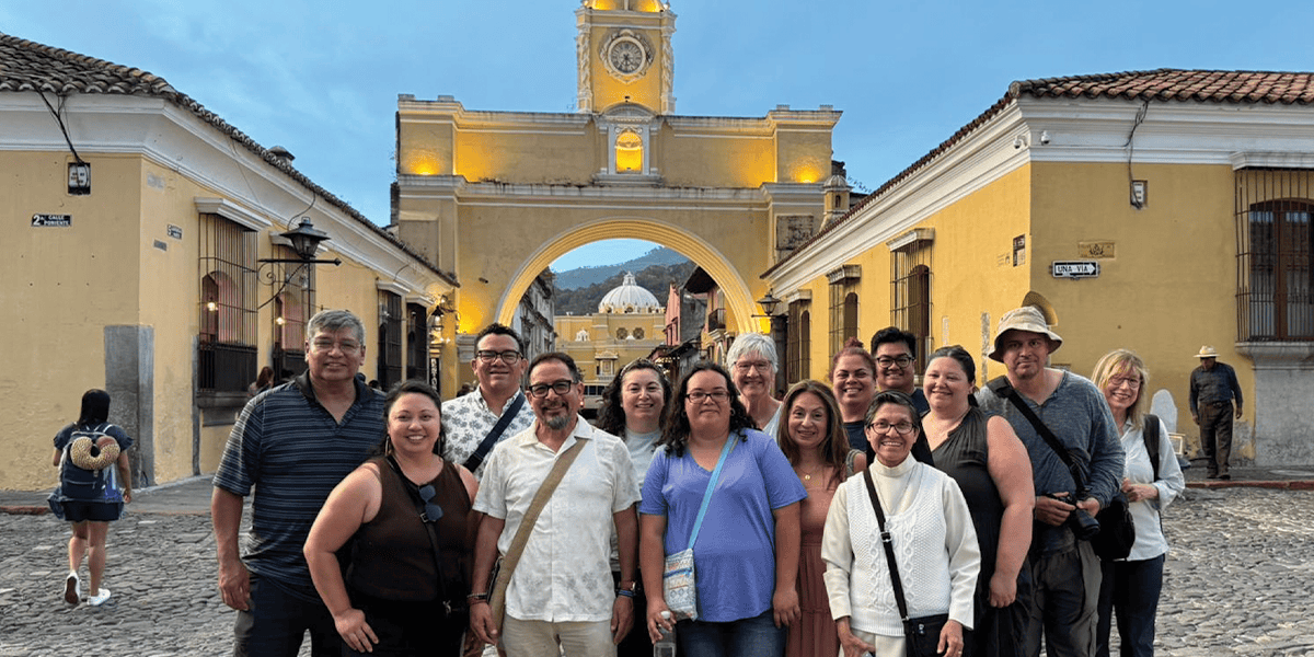 Participantes del viaje de inmersión misionera, incluida Donna Kling Knudson (al centro, con polo blanco y lentes), visitan el Arco de Santa Catalina en la ciudad de Antigua Guatemala. (Leonel Yoque/Guatemala)