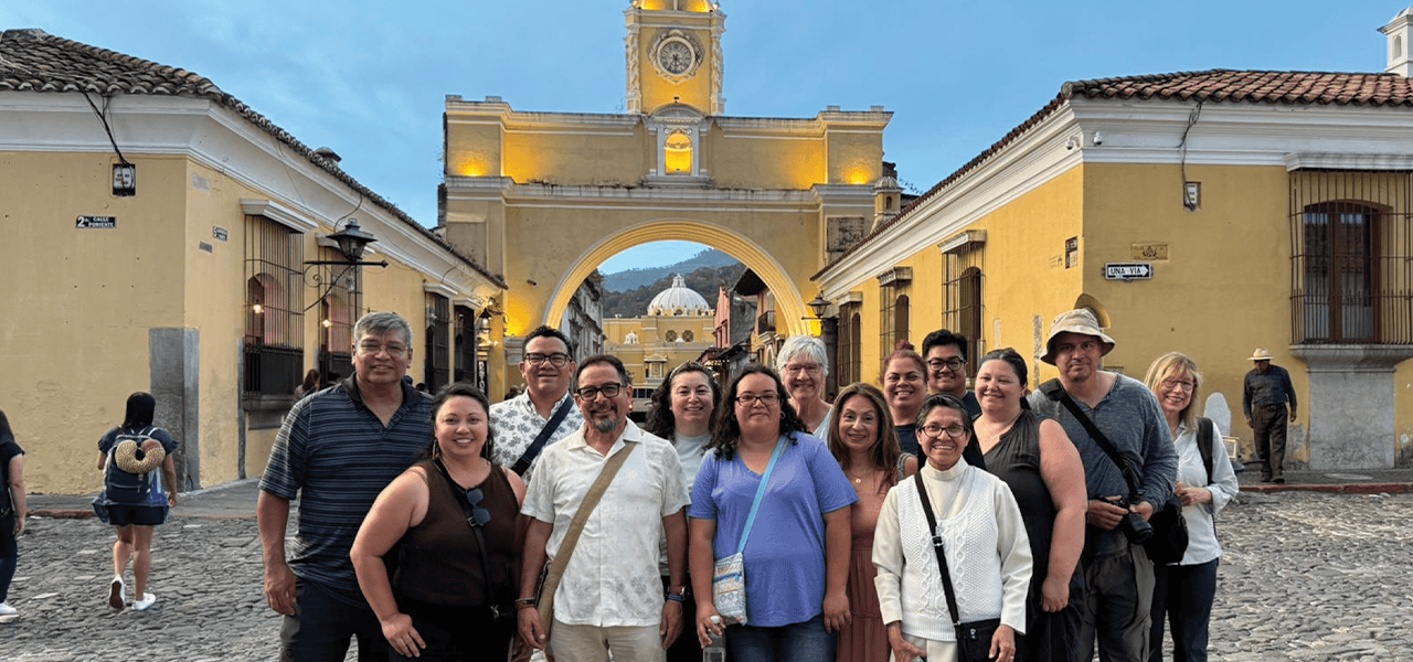 Participantes del viaje de inmersión misionera, incluida Donna Kling Knudson (al centro, con polo blanco y lentes), visitan el Arco de Santa Catalina en la ciudad de Antigua Guatemala. (Leonel Yoque/Guatemala)