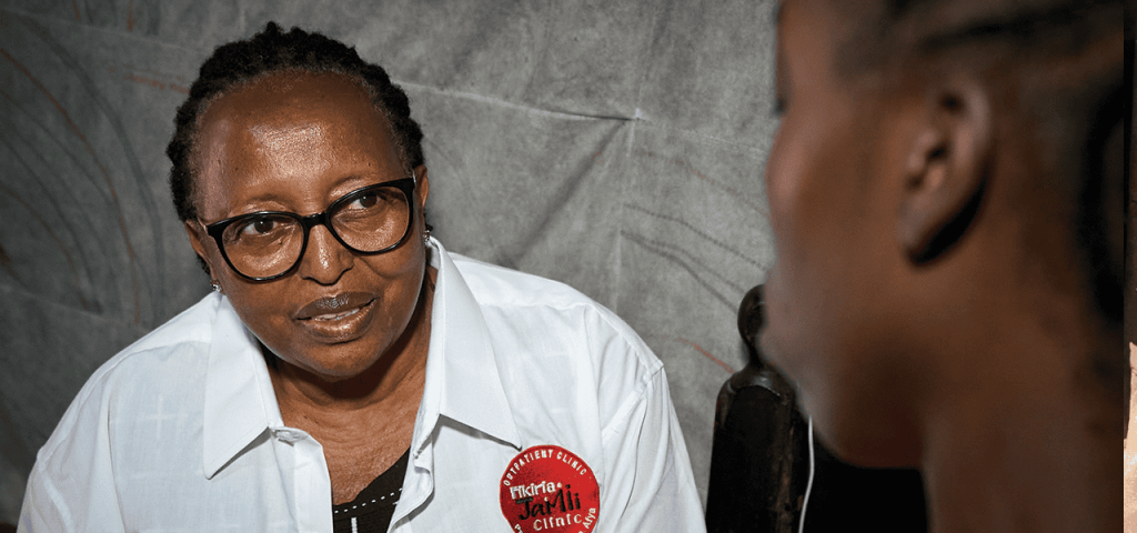 Alice Njoroge, directora general del Programa de Alivio del Sida del Decanato del Este, charla con un cliente. Njoroge dice que 8 de las 14 clínicas de EDARP cerraron por recortes financieros. (Paul Jeffrey/Kenia)