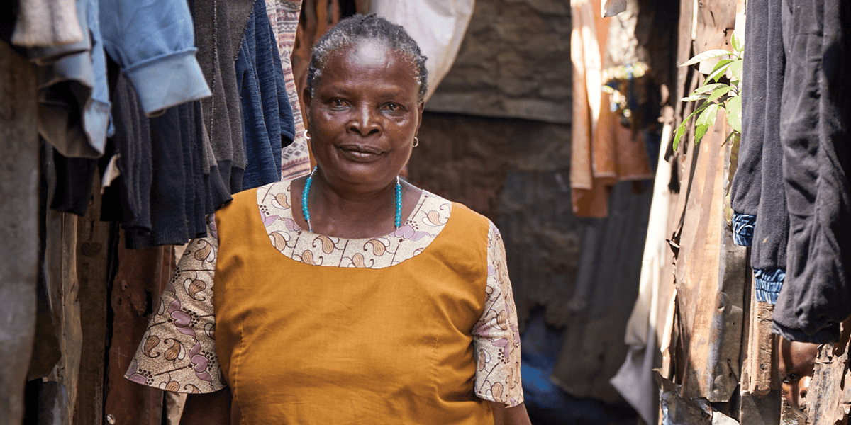 Florence Mwikani camina por un callejón del barrio marginal Mathare en Nairobi, Kenia, donde visita y monitorea a pacientes con sida en su labor como trabajadora de salud comunitaria. (Paul Jeffrey/Kenia)