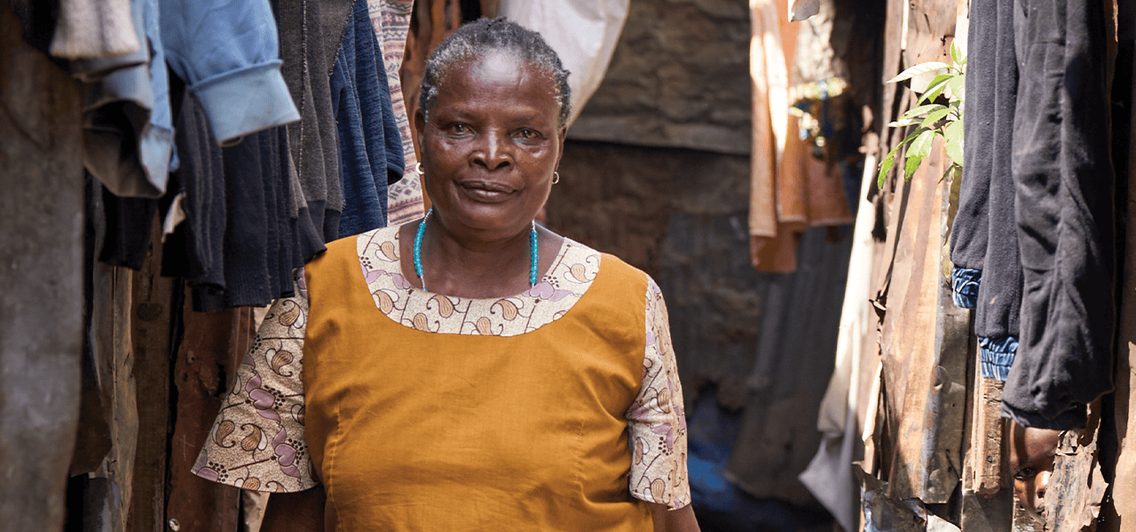 Florence Mwikani camina por un callejón del barrio marginal Mathare en Nairobi, Kenia, donde visita y monitorea a pacientes con sida en su labor como trabajadora de salud comunitaria. (Paul Jeffrey/Kenia)