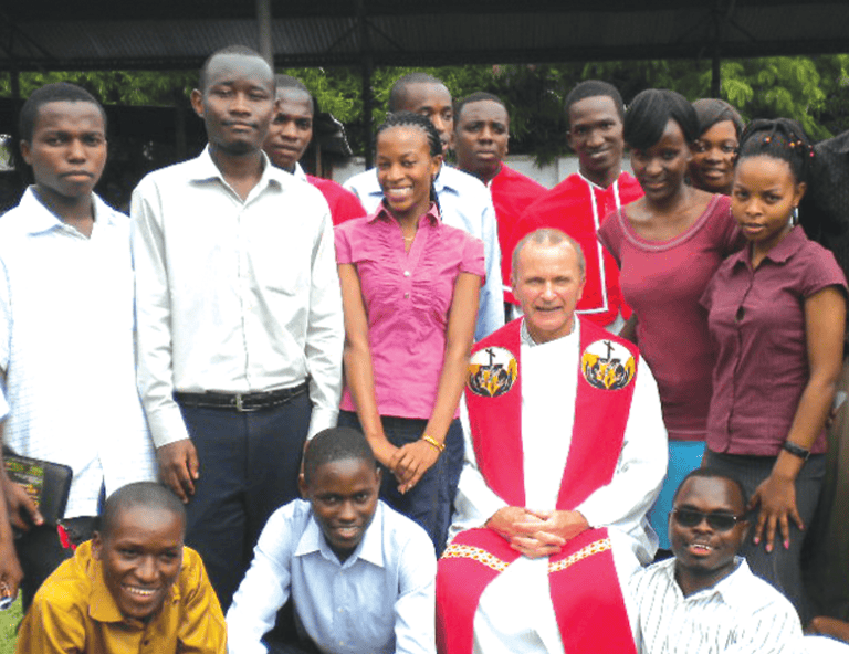 El Padre Maryknoll Michael Snyder rodeado de estudiantes de la universidad nacional en Dar es Salaam. (Cortesía de Michael Snyder, M.M./Tanzania)
