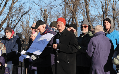 El obispo Bruce Lewandowski (de gorro naranja) de Providence, Rhode Island, dirige una vigilia de oración y rezo del rosario frente a un centro de detención. (Erik Scalavino/EE. UU.)