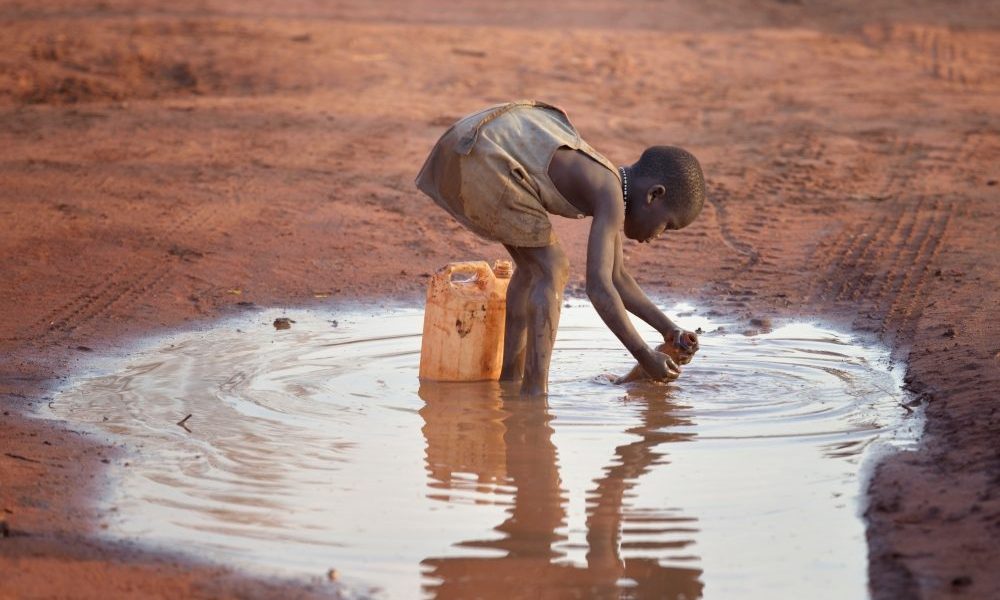 Una niña llena un recipiente con agua fangosa en el campamento de refugiados de Ajuong Thok, en Sudán del Sur, que alberga 40.000 desplazados de las montañas Nuba del vecino Sudán. (Paul Jeffrey/Sudán del Sur)