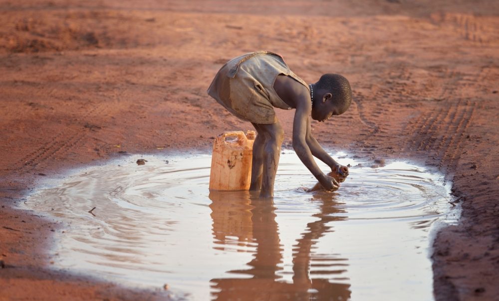 Una niña llena un recipiente con agua fangosa en el campamento de refugiados de Ajuong Thok, en Sudán del Sur, que alberga 40.000 desplazados de las montañas Nuba del vecino Sudán. (Paul Jeffrey/Sudán del Sur)