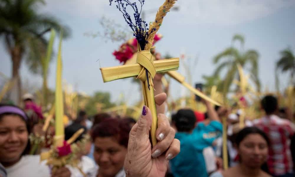 Gente levanta hojas de palma durante una misa del Domingo de Ramos celebrada el 24 de marzo de 2024 en Managua, Nicaragua. (OSV News/Maynor Valenzuela, Reuters)