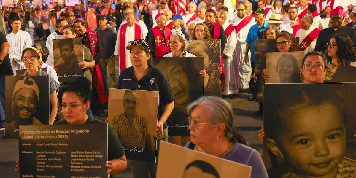 Católicos y otros manifestantes sostienen pancartas con fotografías y nombres de personas que fallecieron en circunstancias relacionadas con la migración, mientras participan en una protesta en El Paso, Texas, el 24 de marzo de 2026, en contra de las deportaciones masivas y las políticas migratorias de la administración Trump. Se puede ver al obispo Mark J. Seitz de El Paso –situado al centro y portando un solideo episcopal– participando en la protesta. (Foto OSV News/José Luis González)