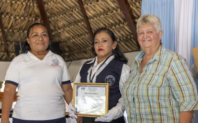 Luz Elizabeth «Lux» Hernández (izq.) y la Hermana Maryknoll Delia «Dee» Smith (dcha.) formalmente incorporan a una candidata como promotora legal comunitaria, otorgándole un chaleco, identificación y diploma. El programa liderado por Lux y la Hermana Maryknoll Dee culminó en una ceremonia de graduación para 18 participantes el 15 de agosto del 2024, en el pueblo de Pajapita en el departamento de San Marcos, Guatemala. (Octavio Durán/Guatemala).