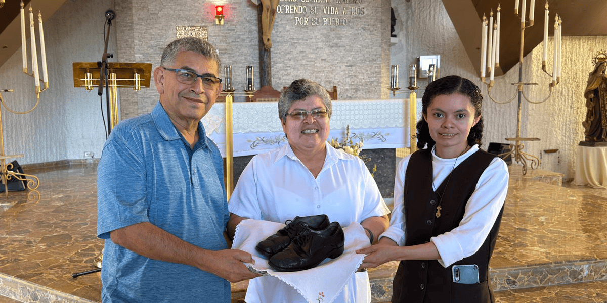 El Hermano franciscano Octavio Durán entrega los zapatos que llevaba San Óscar Romero cuando fue martirizado a la Hermana Tránsito de la Cruz (centro), superiora de la comunidad local de las Carmelitas Misioneras de Santa Teresa, y a la Hermana Reina Mancía, encargada del museo conmemorativo del Hospital Divina Providencia de San Salvador, El Salvador. (Cortesía de Octavio Durán/El Salvador)