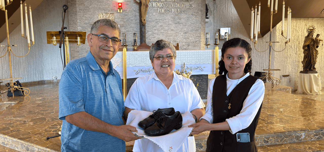 El Hermano franciscano Octavio Durán entrega los zapatos que llevaba San Óscar Romero cuando fue martirizado a la Hermana Tránsito de la Cruz (centro), superiora de la comunidad local de las Carmelitas Misioneras de Santa Teresa, y a la Hermana Reina Mancía, encargada del museo conmemorativo del Hospital Divina Providencia de San Salvador, El Salvador. (Cortesía de Octavio Durán/El Salvador)