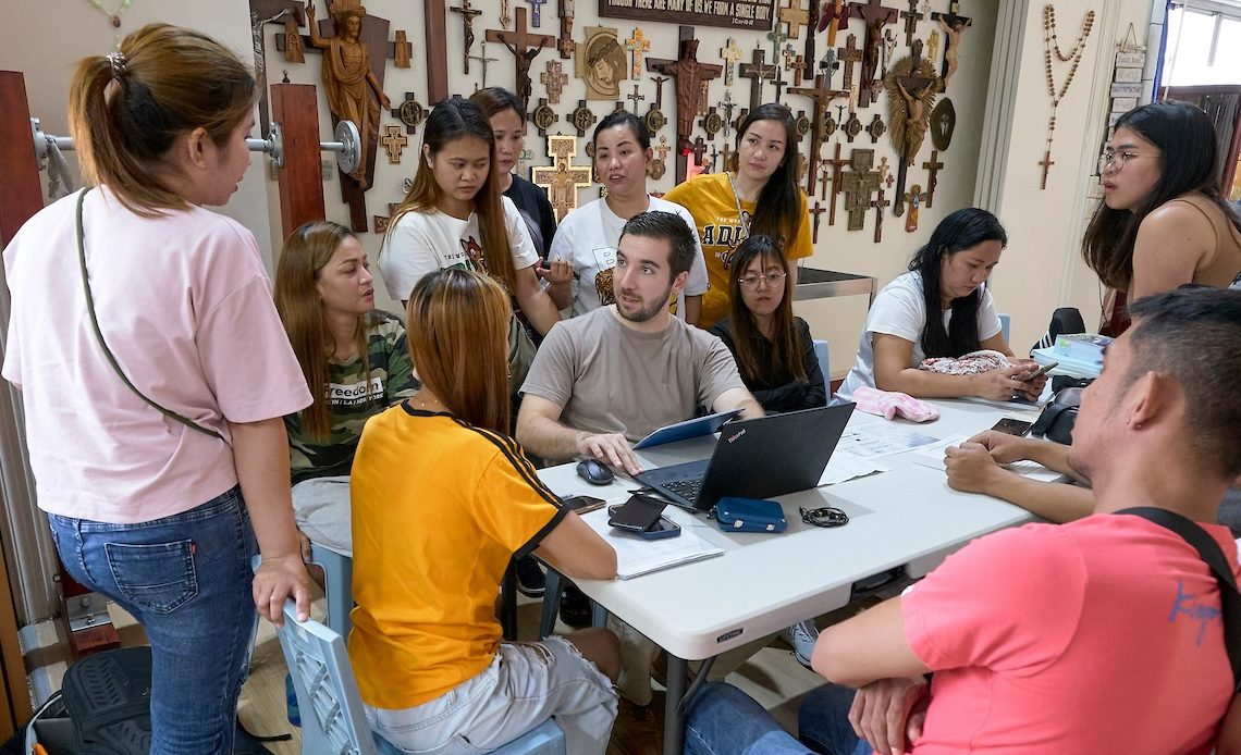 Charles Niece, director de derechos humanos y transparencia en la cadena de suministro, un proyecto de Maryknoll con sede en Taiwán, habla con los trabajadores de una fábrica conflictiva y les informa de sus derechos según la legislación taiwanesa. Se reunieron en la iglesia católica Tanzi de Taichung, que también sirve de refugio para los trabajadores migrantes en situación de crisis. (Paul Jeffrey/Taiwán)