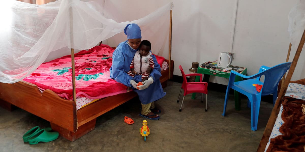 Noella Kavira Kitakya, de 26 años, una superviviente del ébola que trabaja como cuidadora, le pone un zapato a un niño cuya madre falleció a causa del ébola en un centro de UNICEF en Katwa, Congo, en esta fotografía de archivo del 2 de octubre de 2019. El Papa Francisco abrió en 2017 una nueva vía hacia la santidad para los “mártires de la caridad”, aquellos que realizaron sacrificios heroicos durante pandemias y otras situaciones de contagio. (CNS/Zohra Bensemra, Reuters)