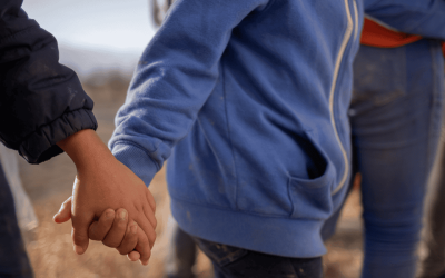 Menores no acompañados procedentes de Centroamérica que buscan asilo en Estados Unidos se toman de las manos mientras esperan transporte en Penitas, Texas, el 12 de marzo de 2021, tras cruzar el Río Grande. (Foto de CNS/Adrees Latif, Reuters)