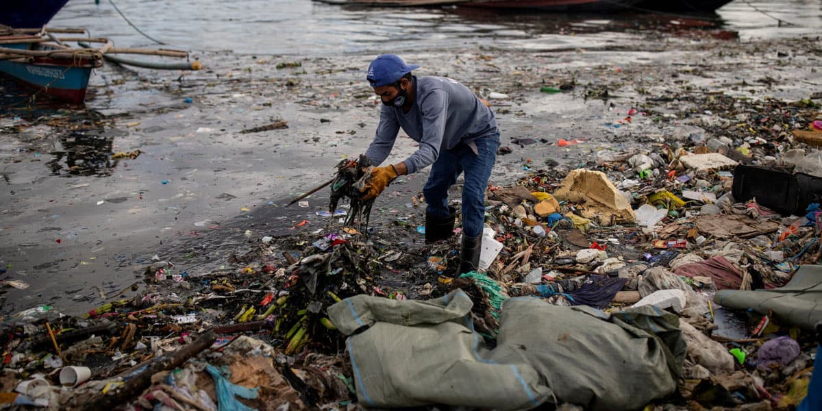Argie Aguirre, integrante de River Warriors, recoge basura del contaminado río Pasig en Manila, Filipinas, el 22 de junio de 2021. Hace 11 años, el 14 de mayo de 2015, el Papa Francisco emitió su encíclica medioambiental histórica “Laudato Si’”. (OSV News / Eloisa Lopez, Reuters)
