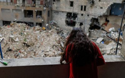 Alaa Dahnoun, de 12 años, quien dijo que sobrevivió a un ataque israelí que la obligó a huir con sus padres a Beirut, mira a través de la ventana dañada de su apartamento en Nabatieh, Líbano, el 18 de abril de 2026, después de que entrara en vigor un alto el fuego de 10 días entre Líbano e Israel. (Foto OSV News/Zohra Bensemra, Reuters)