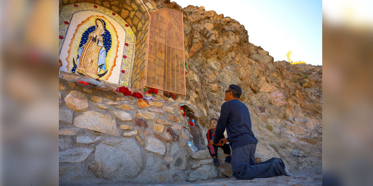 Un hombre reza con un niño frente a una imagen de Nuestra Señora en el Monte Cristo Rey, en Sunland Park, Nuevo México, durante una peregrinación celebrada el 23 de noviembre de 2024 con motivo de la fiesta de Cristo Rey. La Diócesis de Las Cruces ha presentado una respuesta a una demanda interpuesta contra la diócesis y otros demandados por la administración Trump, que busca expropiar el terreno del Monte Cristo Rey, en la frontera entre Estados Unidos y México, para construir partes de su muro fronterizo. (OSV News/José Luis González, Reuters)